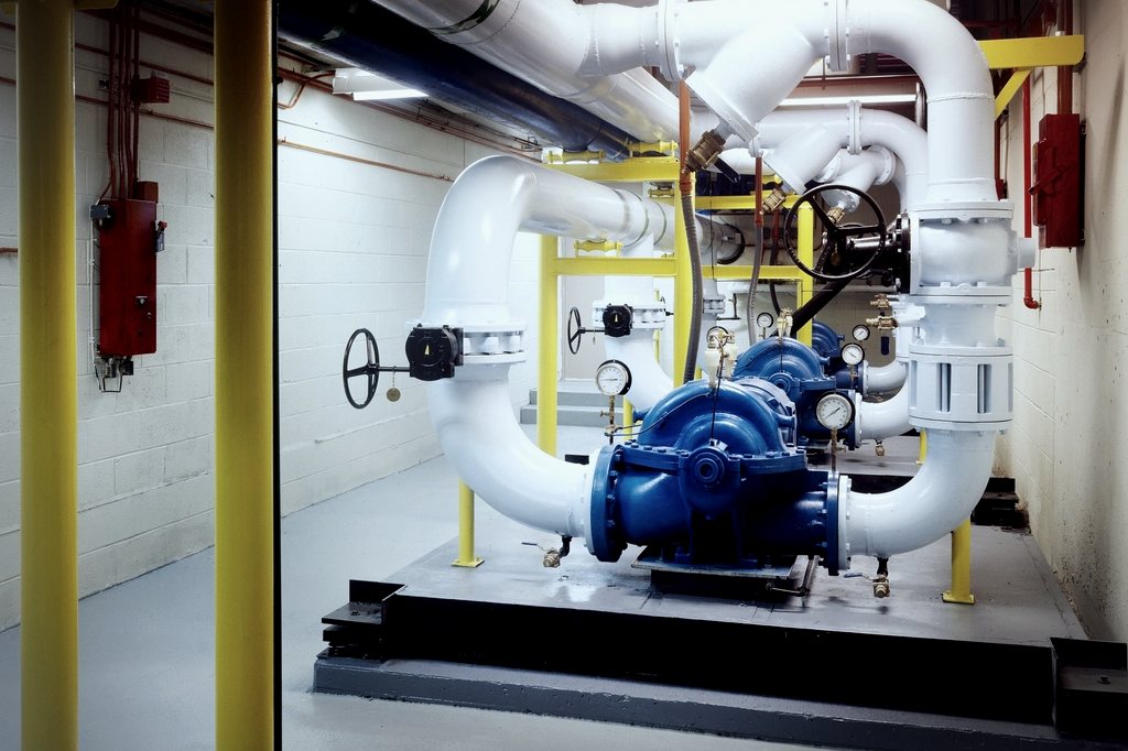 A split-case pump on a housekeeping pad with isolation valves, gauges and flexible connectors.